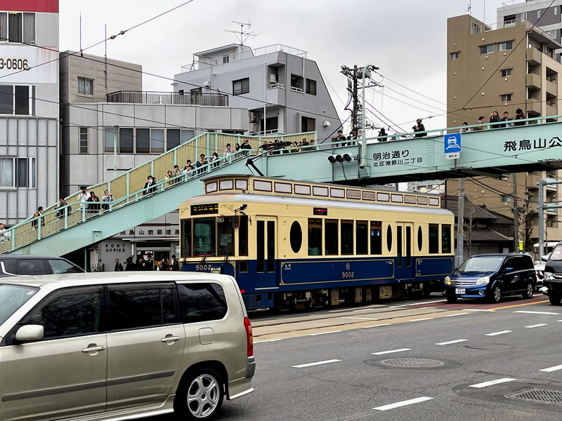 本郷通りが明治通りに交わるあたりを通過する都電と歩道橋上の撮り鉄たち