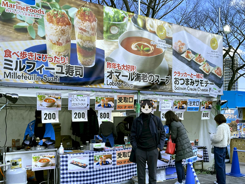魚ジャパンフェス in 代々木公園に出店している「マリンフーズ」のブースの前に立つ私